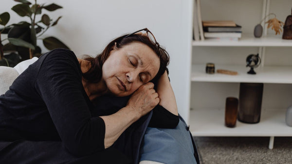Tired woman in her fifties asleep on the sofa in the middle of the day