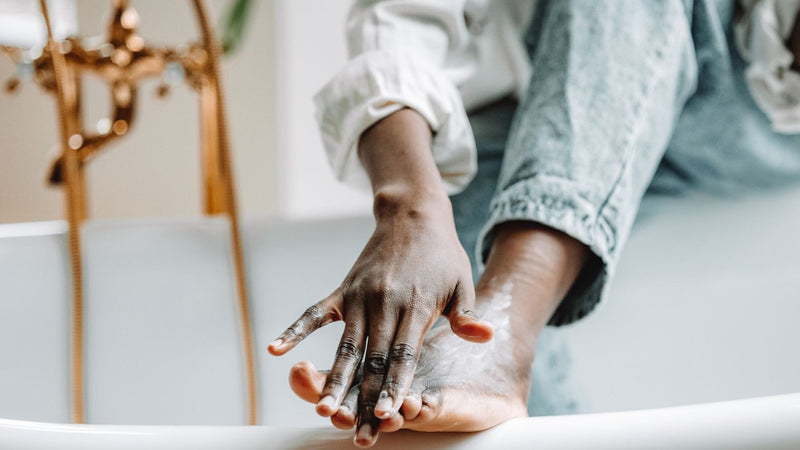 Applying moisturizing cream to dry feet and heels